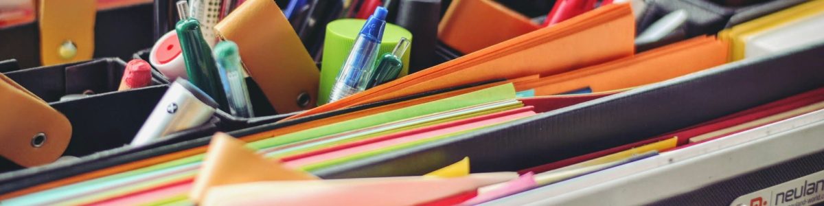 A collection of colorful office supplies neatly arranged in a suitcase, perfect for professionals on the go.